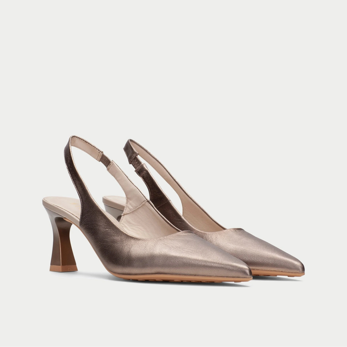 Pair of metallic slingback heels on a light gray background