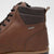 Close-up of a brown leather boot with a visible brand logo on a light gray background