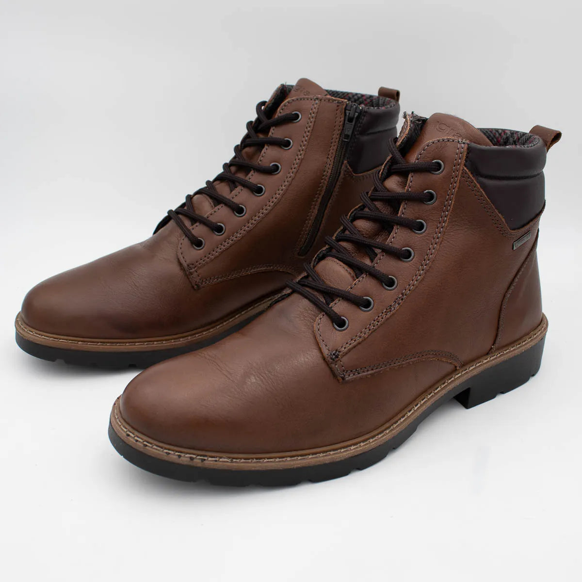 Pair of brown leather boots with black laces on a white background