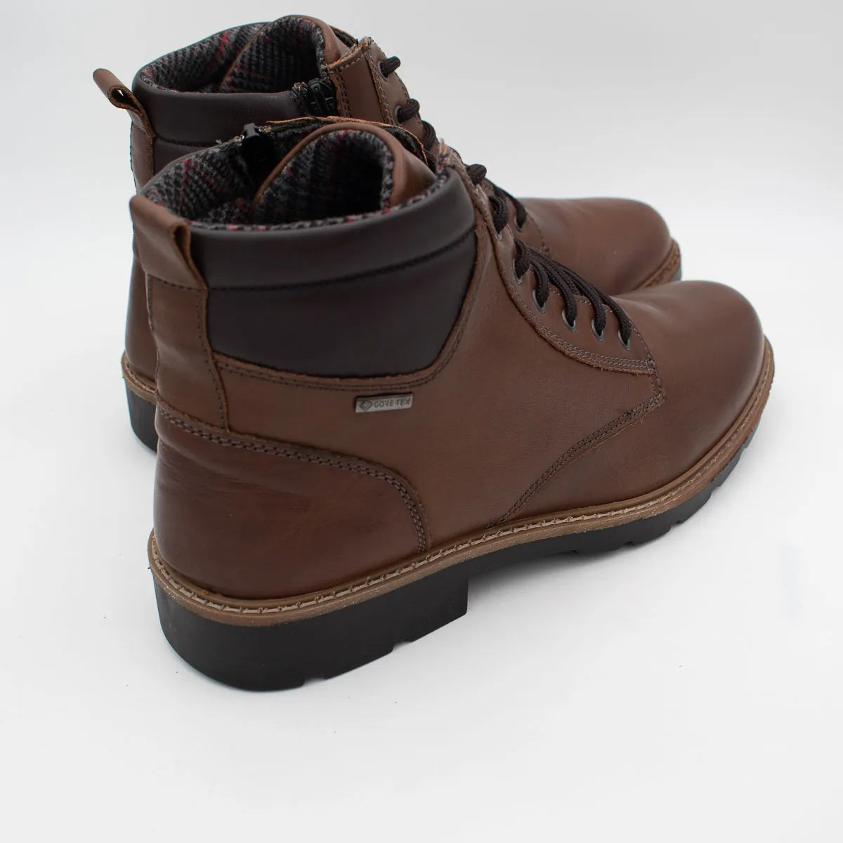 Brown leather boots with black soles on a white background