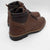 Brown leather boots with black soles on a white background