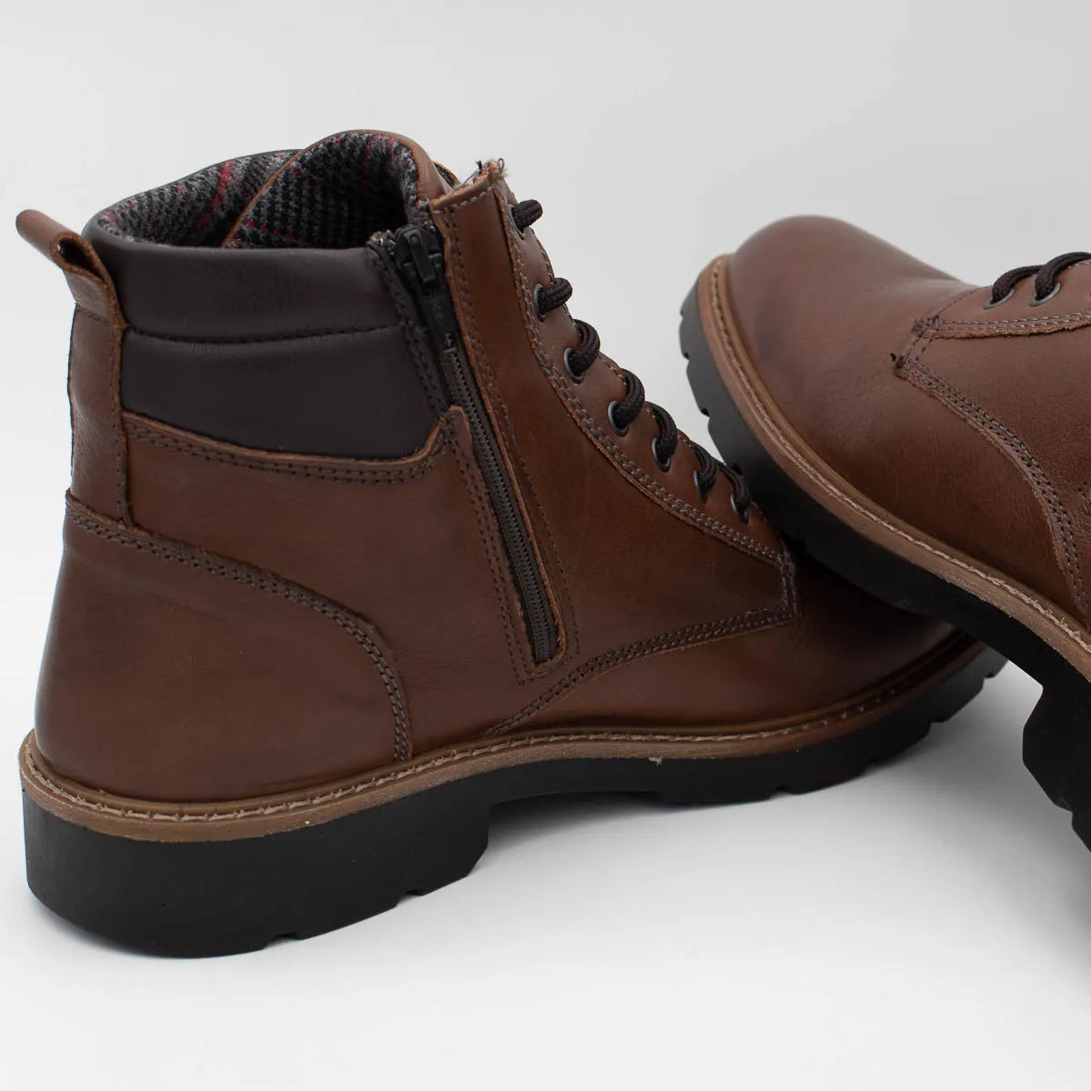 Brown leather boots with a zipper on a white background