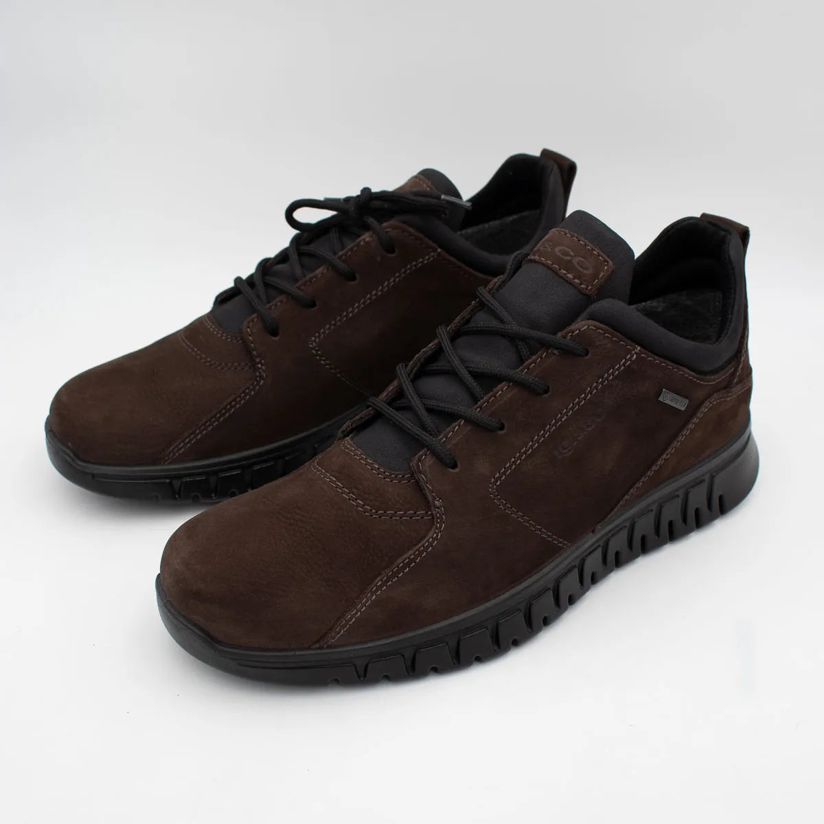 Pair of brown shoes with black laces on a white background