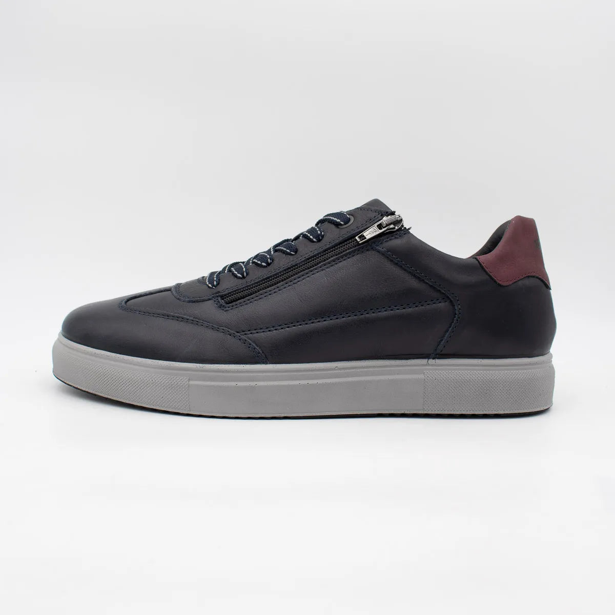 Black sneaker with a white sole on a light gray background
