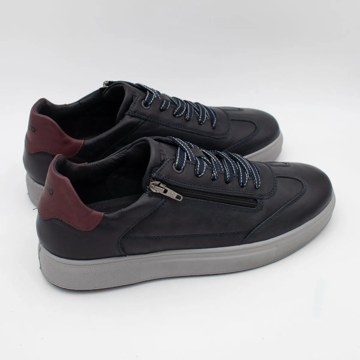 Black sneakers with maroon accents on a white background