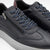 Dark gray sneakers with navy laces and a zipper on a light gray background