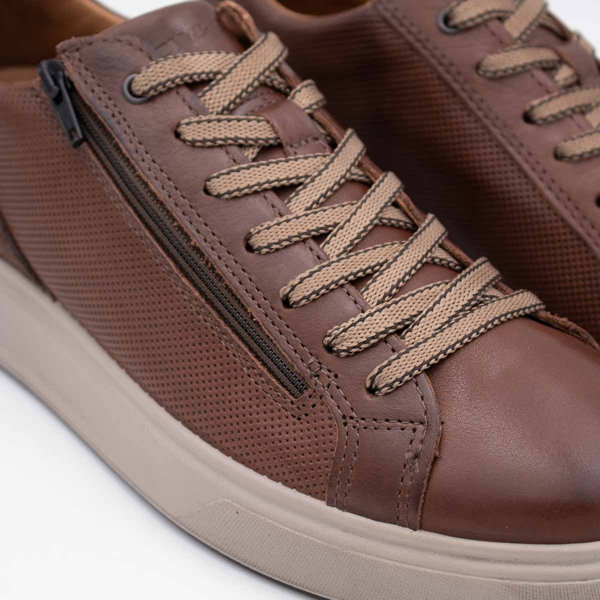 Brown leather sneaker with laces on a white background