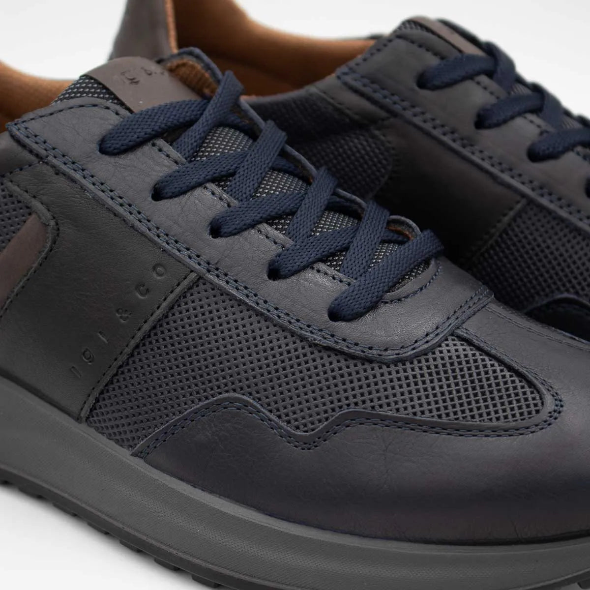 Navy blue sneakers with dark gray soles on a white background