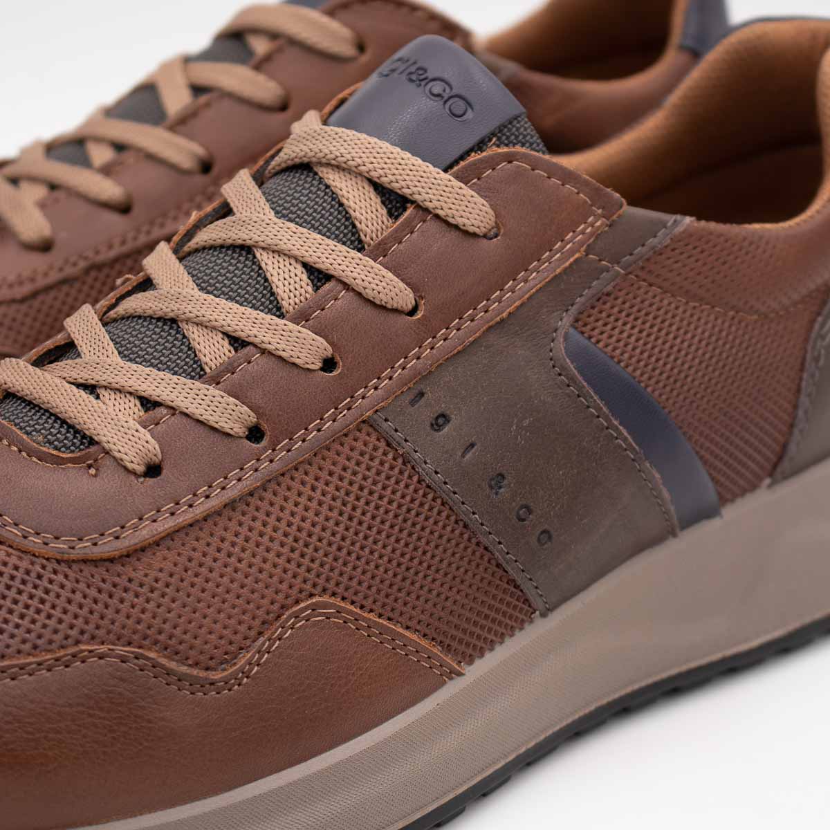 Brown leather sneaker with visible brand logo on a white background