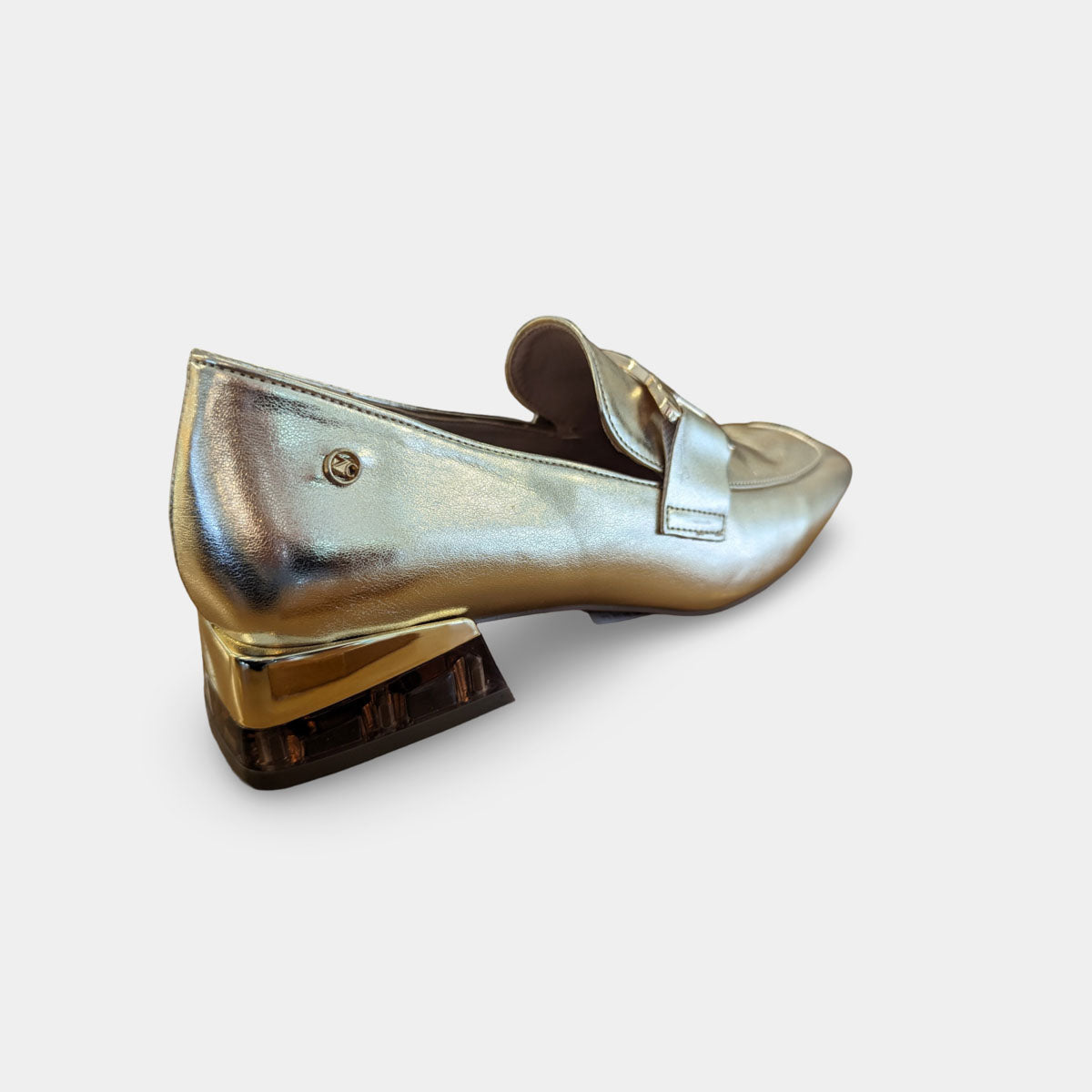 Detailed view of the loafer's sleek cream upper and stylish flat block heel.