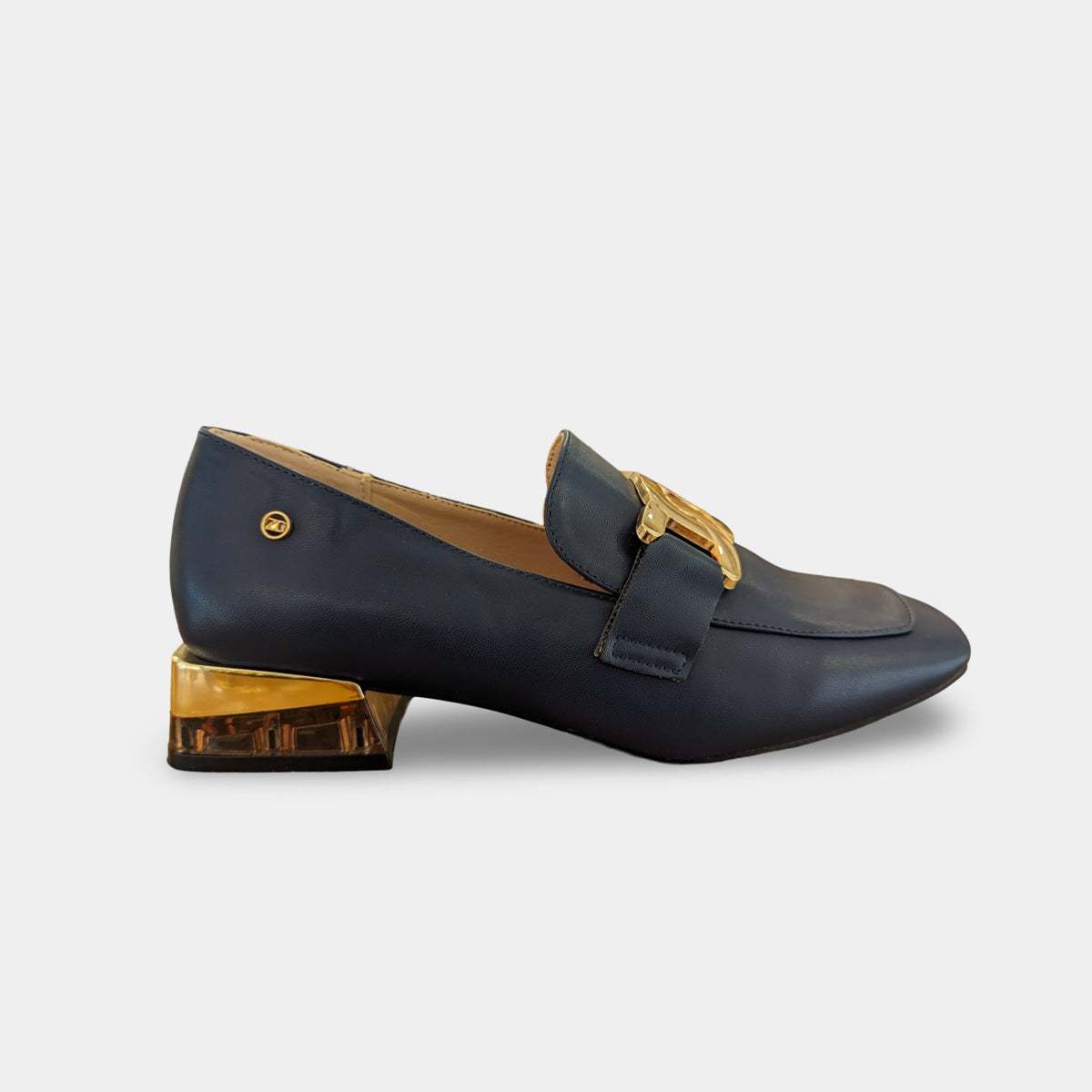Detailed view of the navy loafer's elegant upper with gold accents.