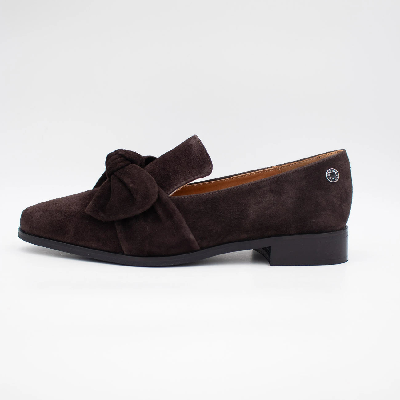 A single dark brown suede loafer with a bow detail on the vamp and a low block heel, shown from a side profile against a clean white background.