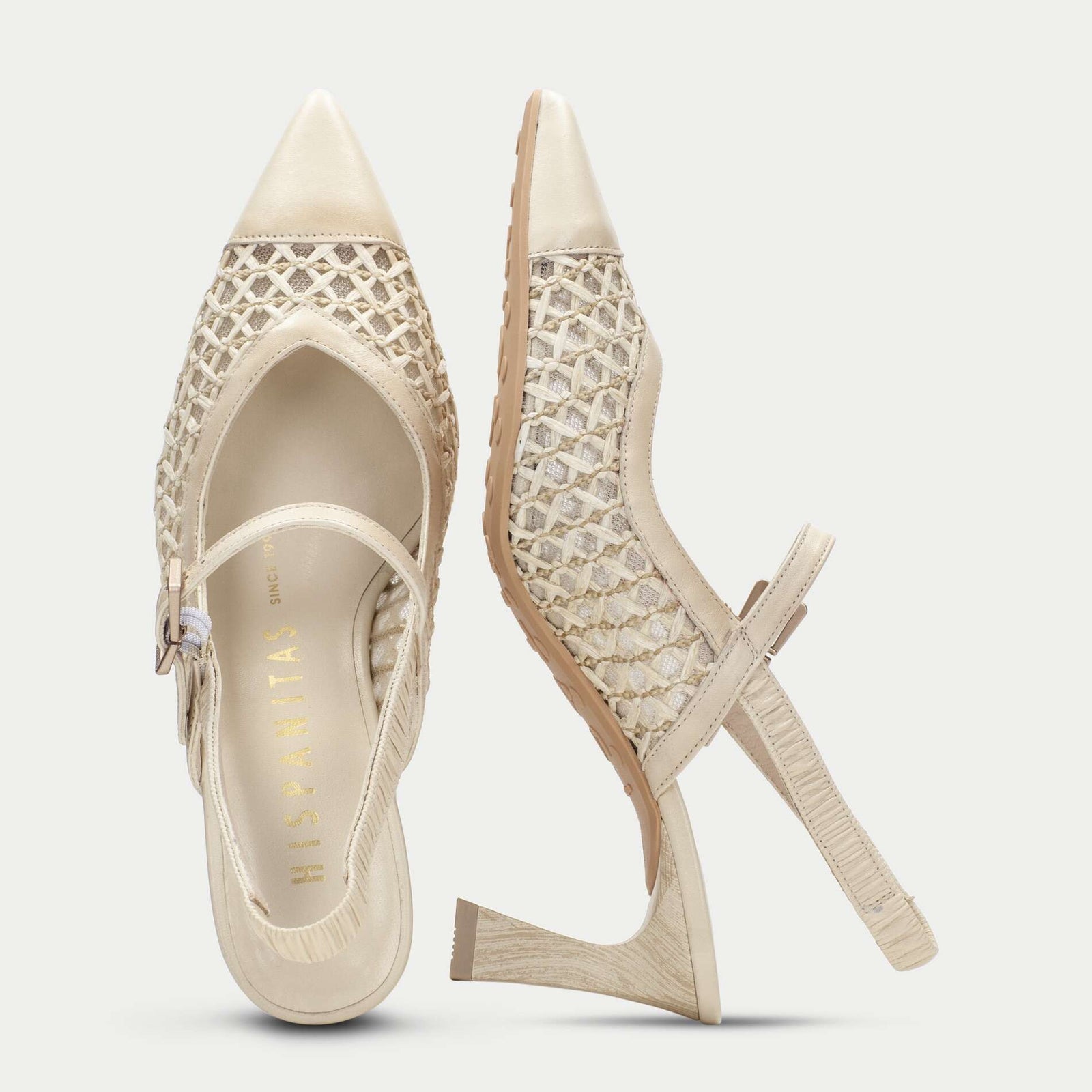 Pair of beige high-heeled shoes with detailed design on a light gray background