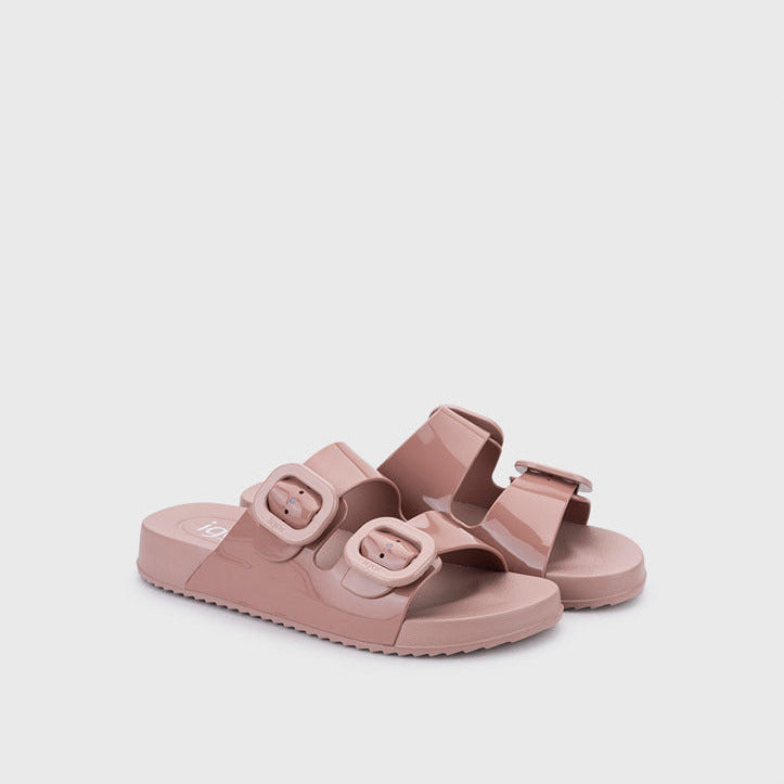 Pair of pink sandals with buckles on a light gray background