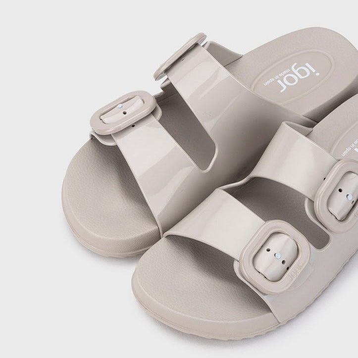 Pair of light gray sandals with buckle straps on a white background