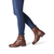 Woman confidently modelling the brown leather ankle boots with blue jeans.