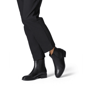Stylish woman modeling the Black Chelsea ankle boot with pants.