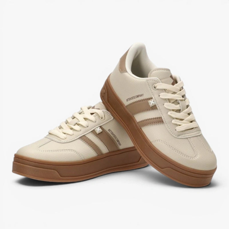 Pair of beige sneakers with brown soles on a white background