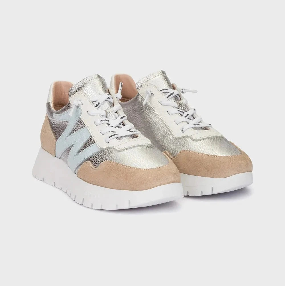 Pair of beige and silver sneakers on a light gray background