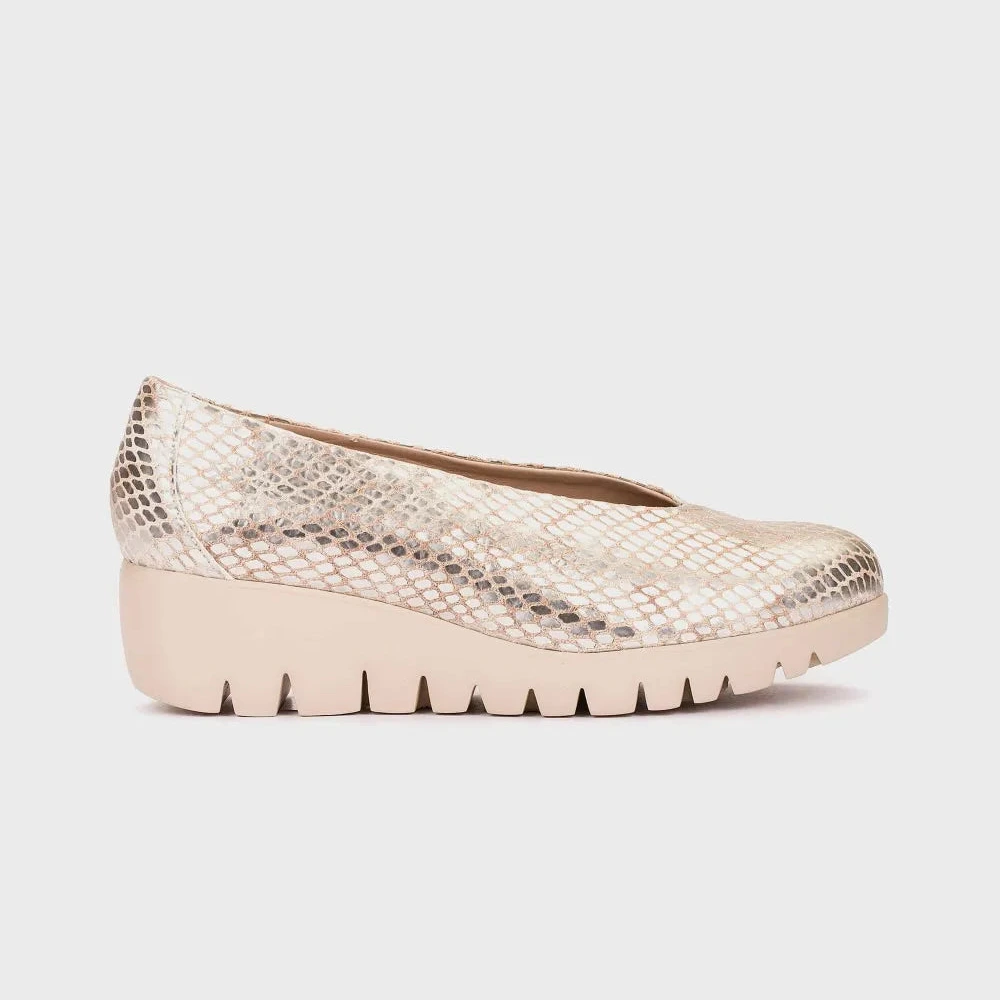 Beige wedge shoe with snake print pattern on a white background