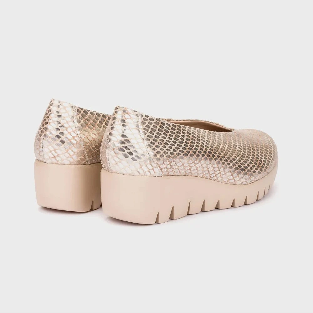 Pair of beige platform shoes with snake print on a light gray background