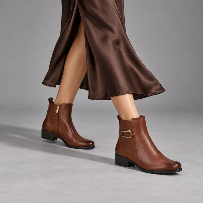 Caprice cognac leather ankle boots worn with a chocolate satin midi skirt in a grey studio.