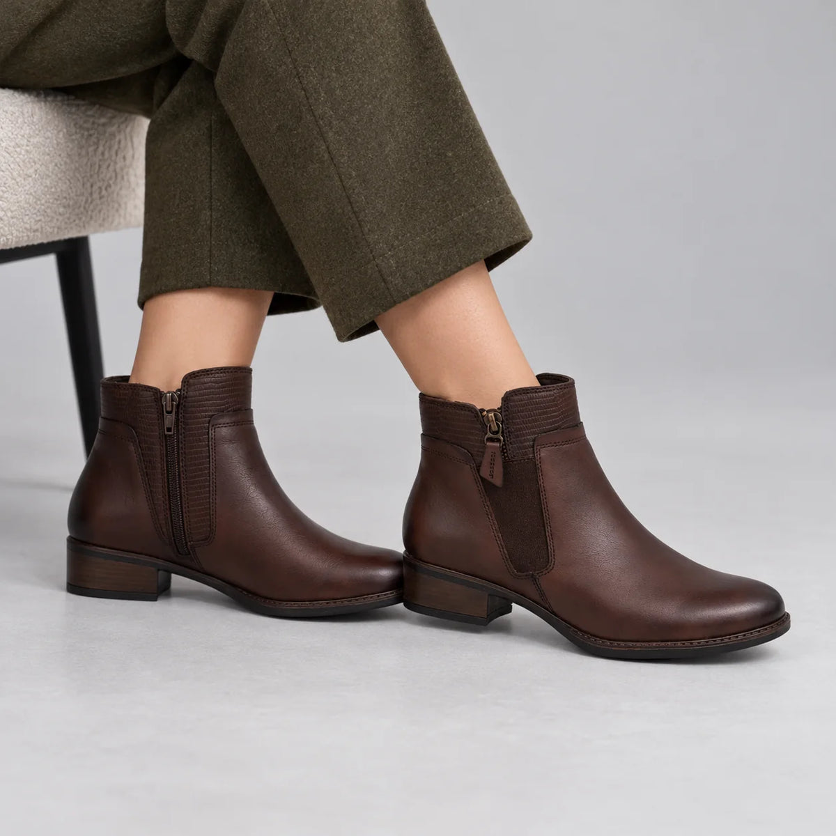Dubarry Cierra Mahogany Leather Ankle Boots worn by a female model, showing the inside zip and outer detailing in a grey studio