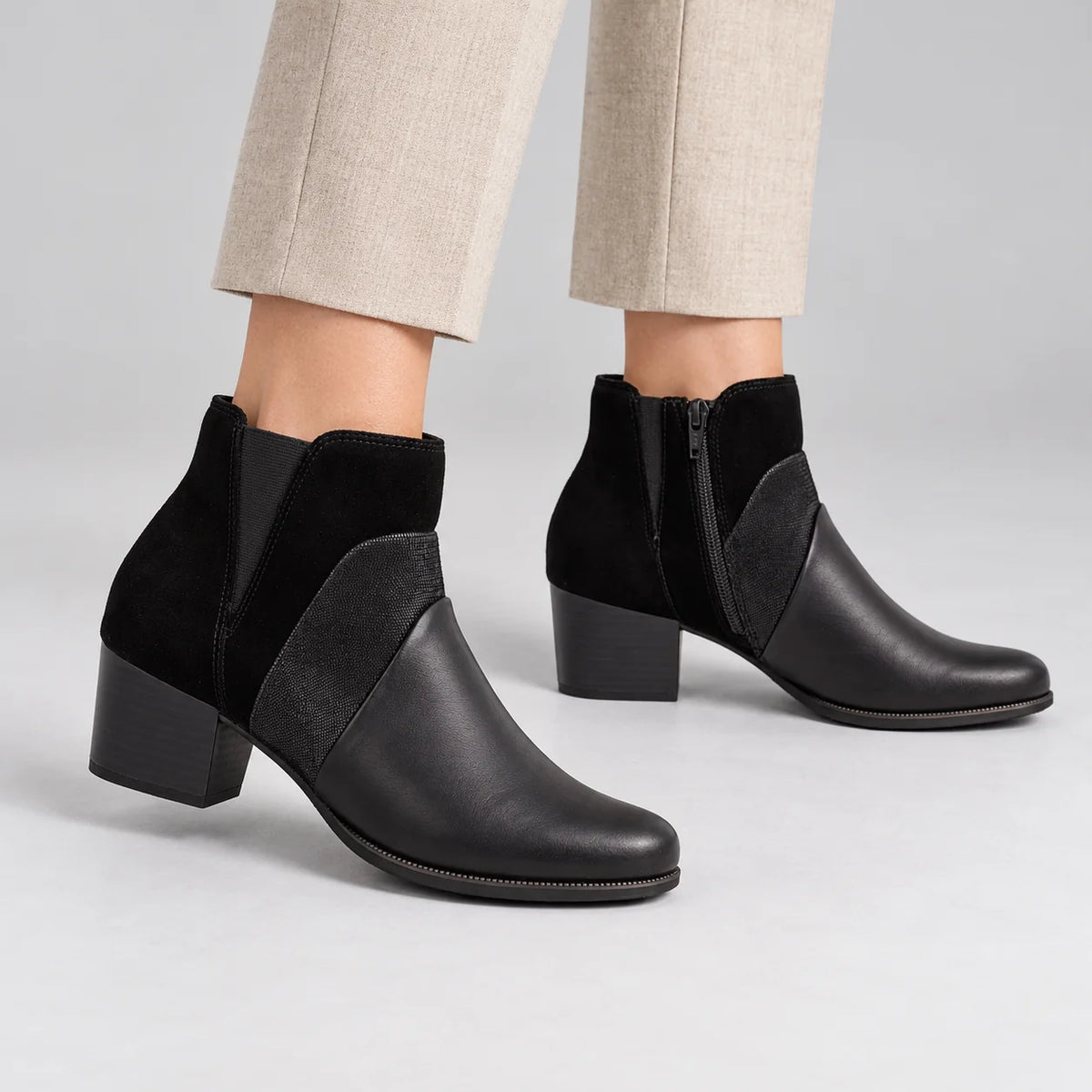 Dubarry Cindy Black Leather Block Heel Ankle Boots worn by a female model, showing the inside zip and outer detailing in a grey studio