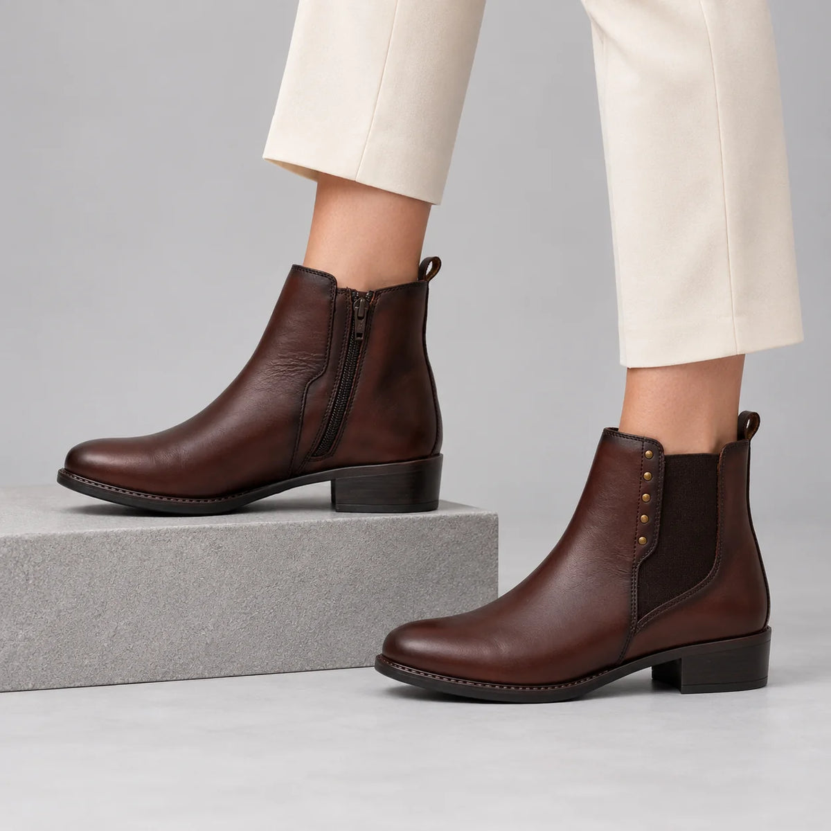 Dubarry Crest Chestnut Leather Chelsea Ankle Boots worn by a female model, showing the inside zip and outer detailing in a grey studio
