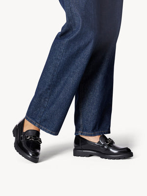 Woman weaing the loafers with dark blue denim jeans.