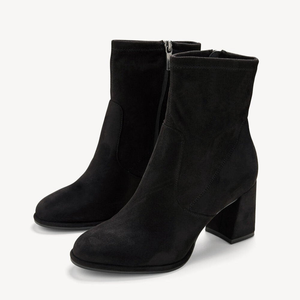 Black suede ankle boots on a white background
