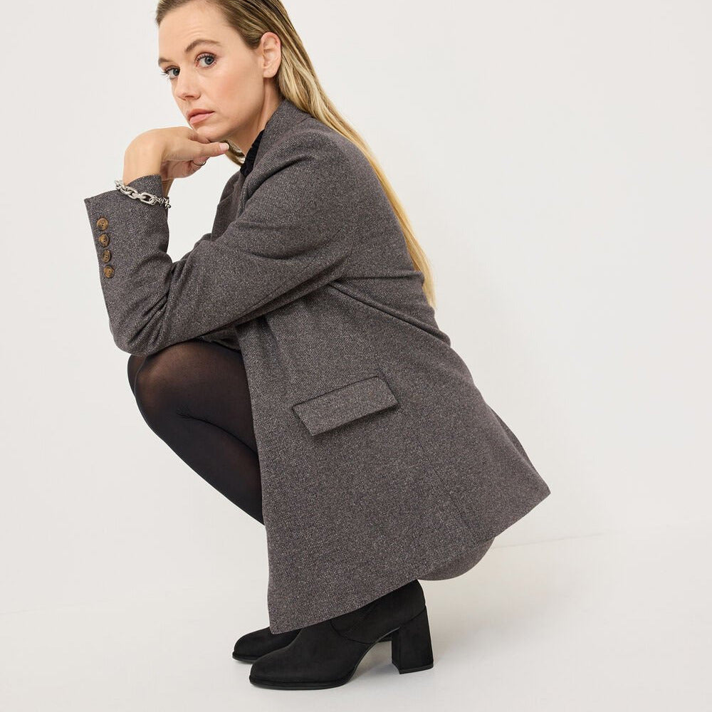Woman wearing a gray coat on a white background