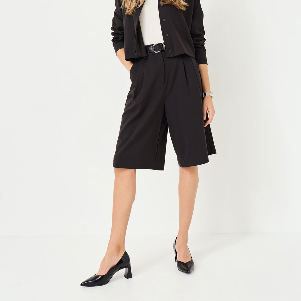 Woman wearing a black outfit with a white background