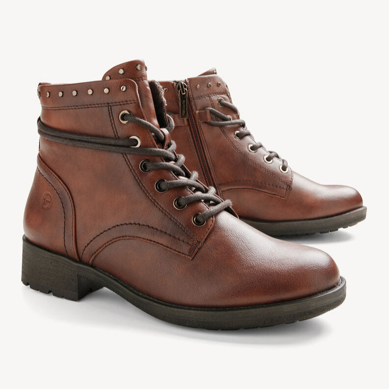 Pair of brown leather boots with studded details on a white background