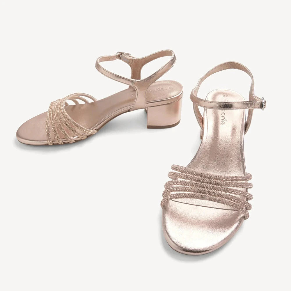 Pair of rose gold sandals on a white background