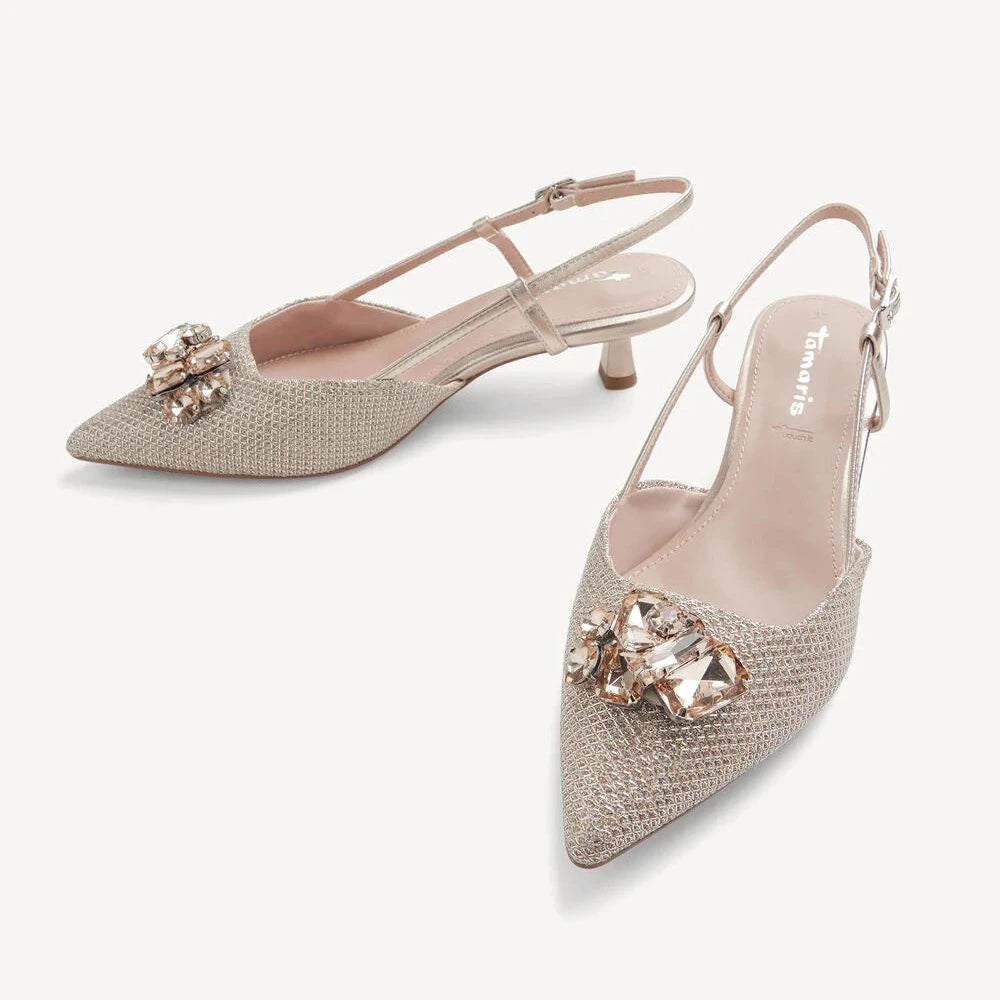 Pair of beige high-heeled shoes with crystal embellishments on a white background
