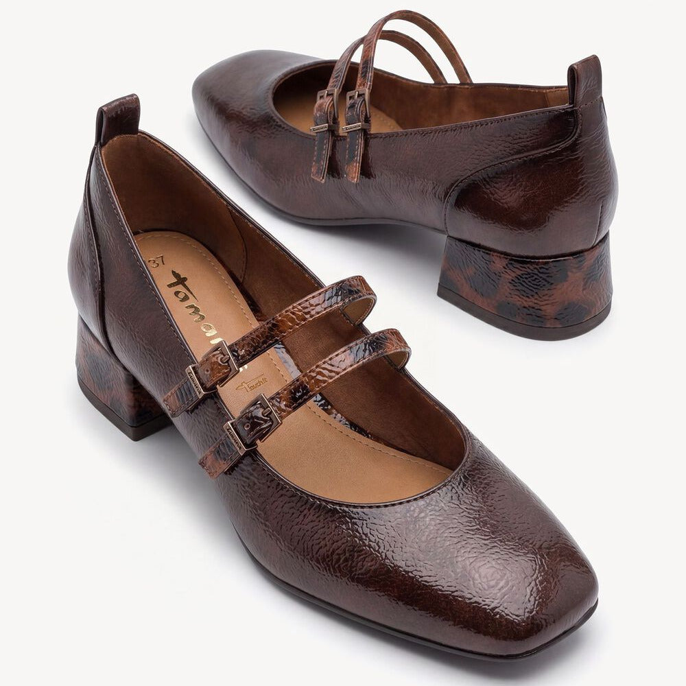 A pair of dark brown Mary Jane block heels with textured straps and a snakeskin-patterned heel accent, shown on a clean off-white background.
