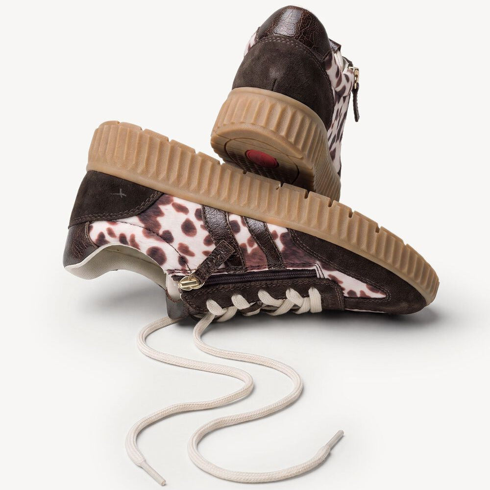 A pair of low-top platform sneakers with dark brown leather and a brown-and-white animal print pattern, featuring chunky beige gum soles and off-white laces, shown on a light gray background.