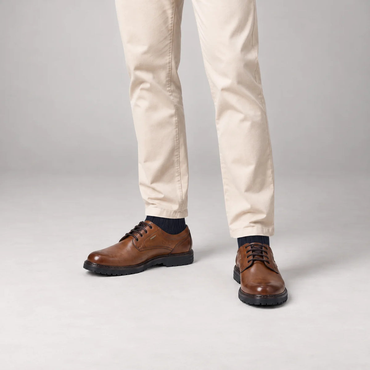 Male model wearing socks and Josef Seibel Erroll 50 in Cognac, square studio footwear view