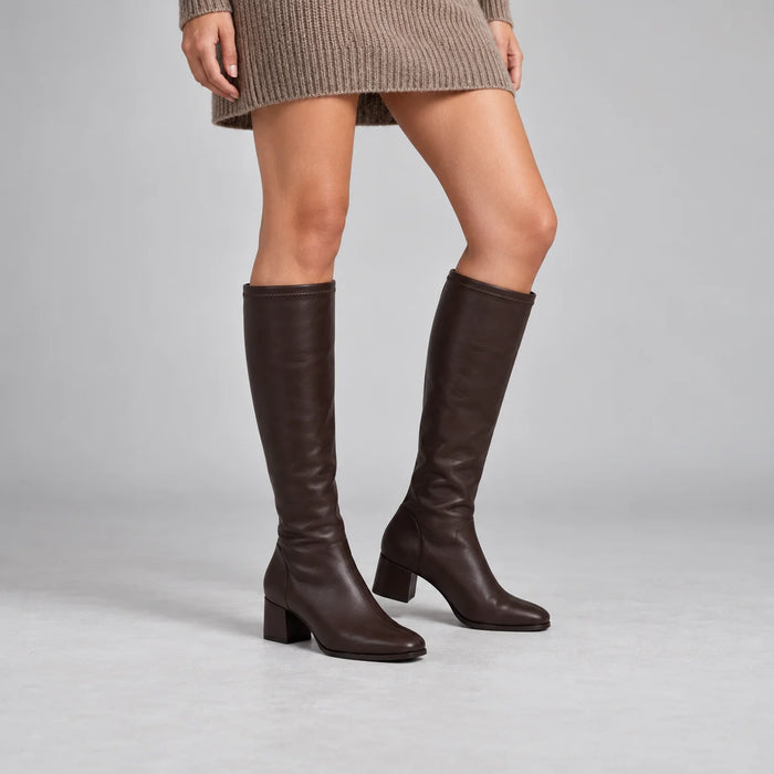 Miss Elastic Brown Leather-Look Stretch Knee-High Boots worn by a female model in a neutral grey studio