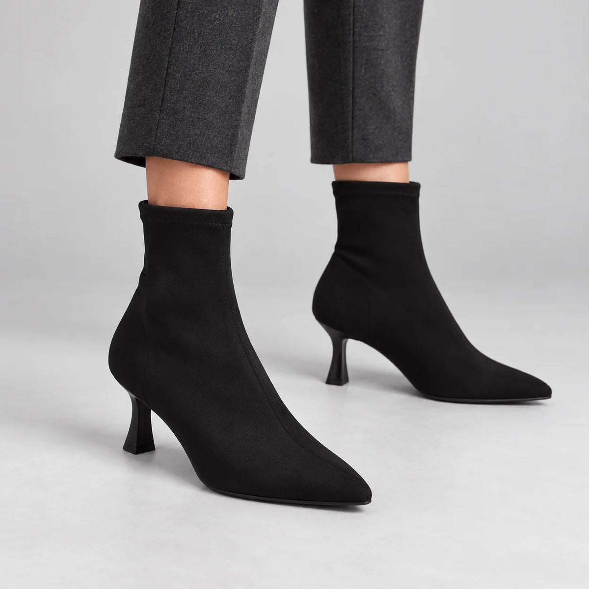 Miss Elastic Black Suede-Effect Stretch Ankle Boots worn by a female model in a neutral grey studio