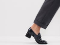 Woman styling the Tamaris Black Block Heel Loafers with a pants suit.