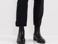 Video showcasing a woman elegantly pairing the boots with black pants.