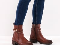 Video of a woman showcasing the versatility of the brown leather ankle boots by Tamaris, paired perfectly with blue jeans.