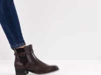 Woman wearing the Tamaris navy leather ankle boot in a different colour but the same style.