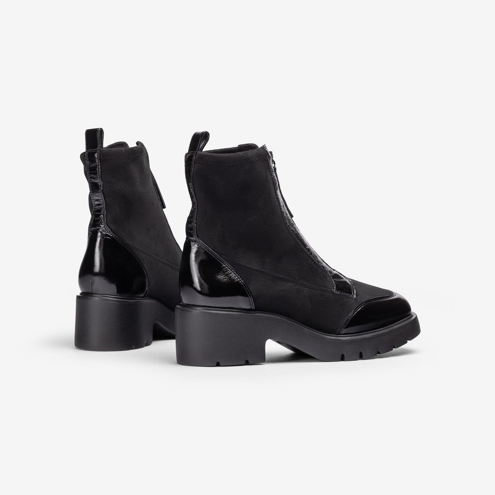 Unisa Jandro black stretch and patent ankle boots showing rear pull tabs, glossy heel panels and treaded soles