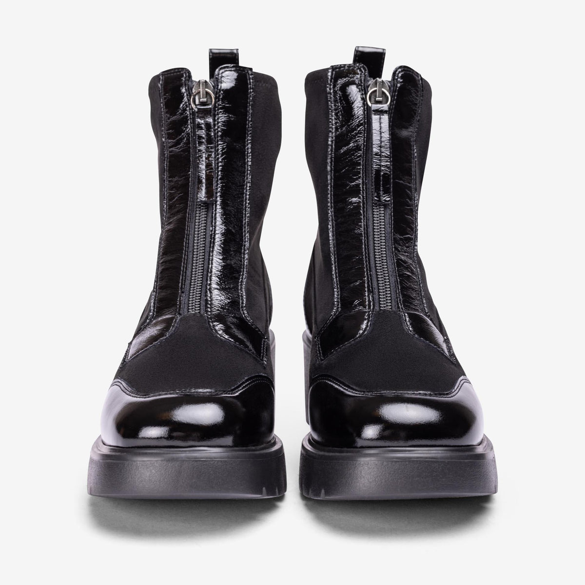 Front view of Unisa Jandro black ankle boots showing front zips, glossy patent toe caps and platform soles