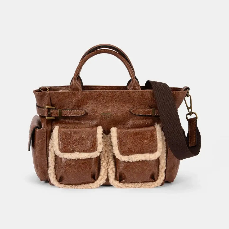 Brown leather bag with shearling pockets on a white background