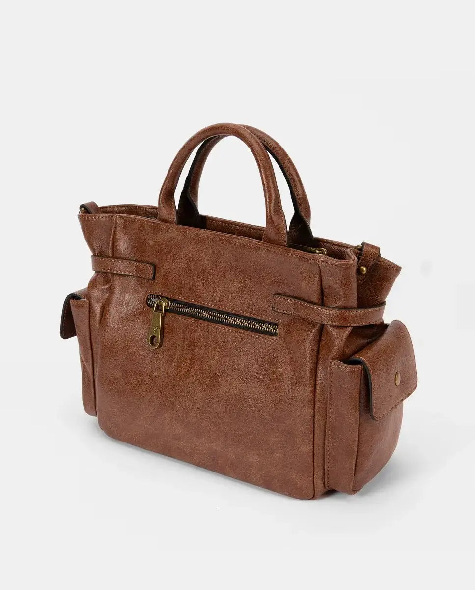 Brown leather handbag with gold zipper on a light gray background