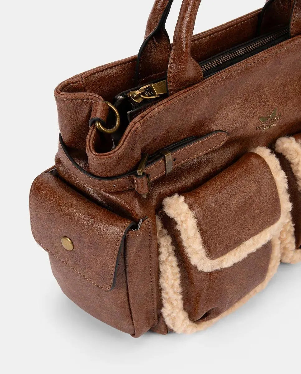 Brown leather bag with shearling lining on a light gray background